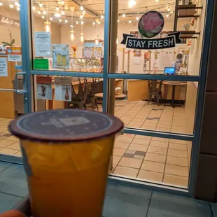 Peach melon green tea in front of store.