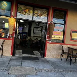 Open doors and two tables outside.