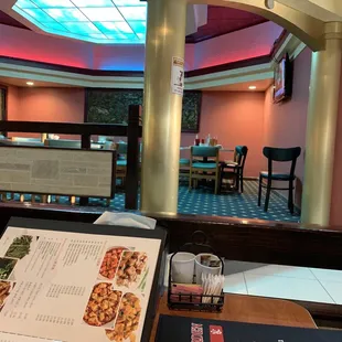 a woman sitting at a table with a menu in front of her