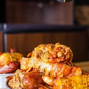 a person dipping sauce over a plate of chicken wings