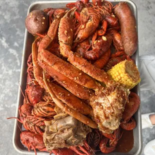a platter of lobsters, corn, and sausage