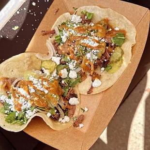 Chopped Brisket Tacos with grilled onions, cilantro, and Queso Fresco, and BBQ sauce.