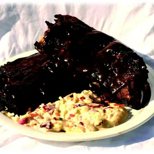 a plate of ribs and coleslaw