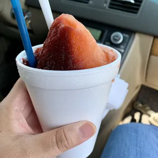 ows a hand holding a cup of ice cream