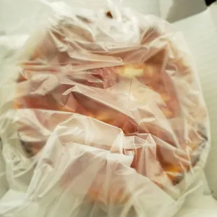 a pizza wrapped in plastic
