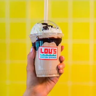 a hand holding a cup of ice cream