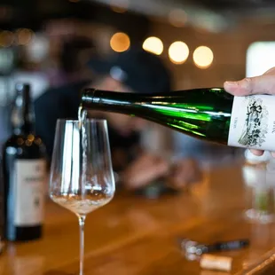 a person pouring a glass of wine