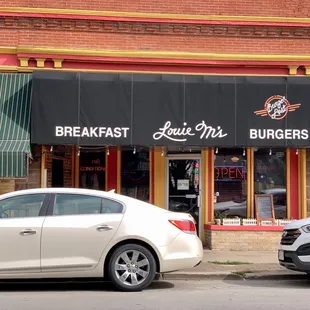 two cars parked in front of a restaurant