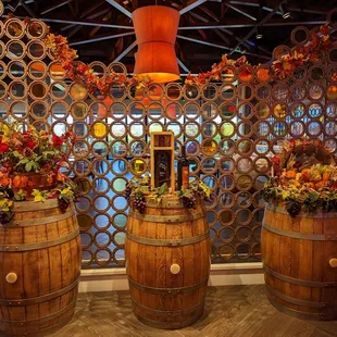 three wooden barrels with flowers in them