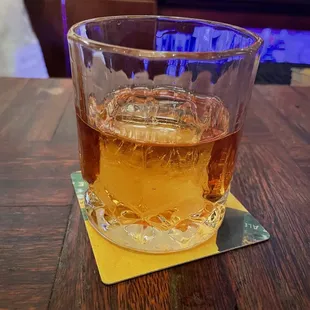 a glass of whiskey on a coaster