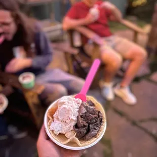 a hand holding a cup of ice cream