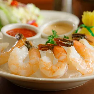 a plate of shrimp with dipping sauce