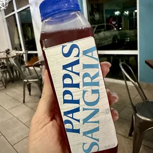a hand holding a bottle of syrup