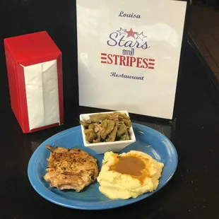 a plate of mashed potatoes, gravy, and green beans