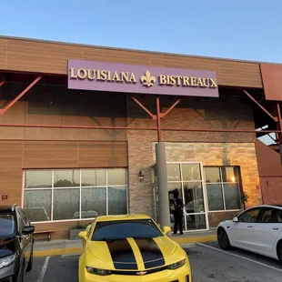 a yellow sports car parked in front of a restaurant