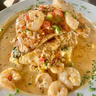 Salmon stacked topped with shrimp on a bed of grits