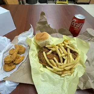 Fried chicken, fries, drink, dinner roll and fried shrimp.