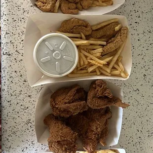 three trays of fried chicken and french fries