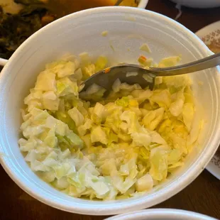 a bowl of cabbage and a spoon