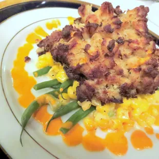 Crab cake over light corn maque choux and roasted red pepper remoulade