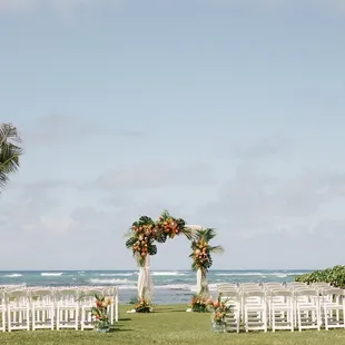 Lawn ceremony setup with chuppah and white chairs