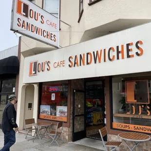 a man walking past a sandwich shop