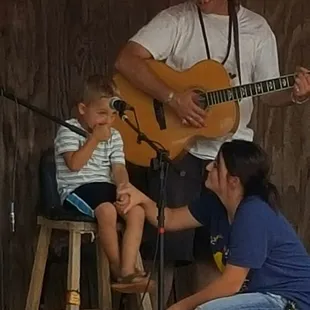 a man playing guitar with a young child