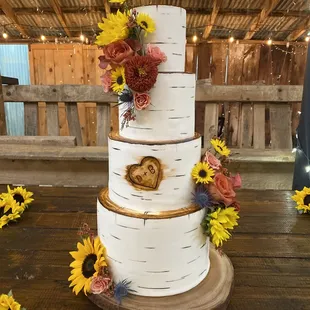 a three tiered cake decorated with sunflowers