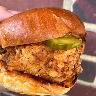 a hand holding a sandwich