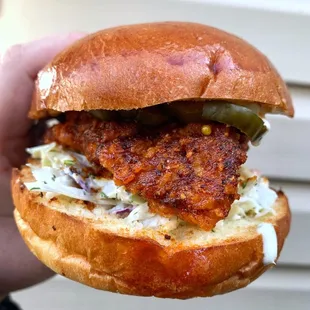 a hand holding a sandwich