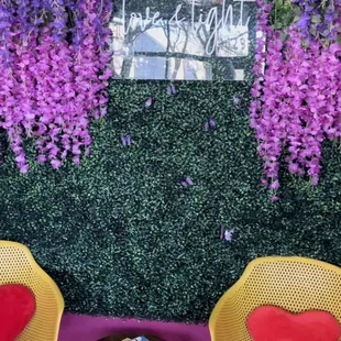 two yellow chairs and a pink wall