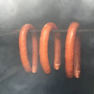 Our juicy beef/pork sausage links smoking in the upright!