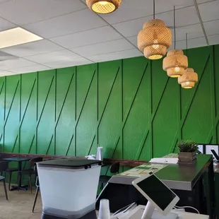 a green wall and a computer desk