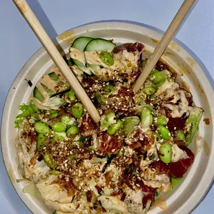 a bowl of food with chopsticks