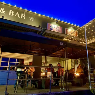 a group of people sitting outside a bar