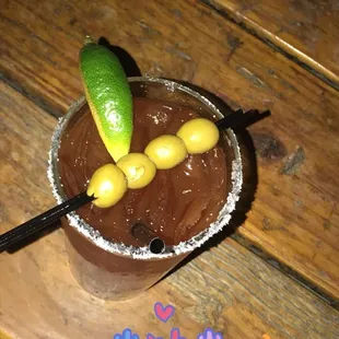 a bloody drink with a lime on the rim