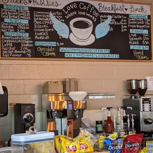 Picture shows a menu listing hot &amp; cold coffees, lunch salads, etc. The bottom of the picture shows a coffee pot &amp; a counter with chips.