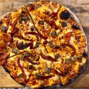 Sausage and Peppers- The classic dinner reinvented into a pizza, sweet and spicy Italian sausage with roasted peppers top off this pizza
