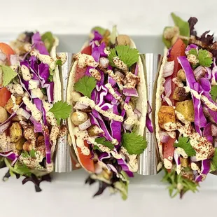 three tacos on a white plate