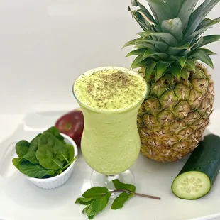 a pineapple, cucumber, and a cucumber smoothie