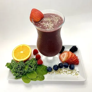 a smoothie with strawberries, blueberries, and oranges