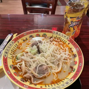 a plate of noodles with meat and vegetables