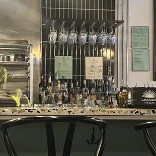 a bar with wine glasses on the counter