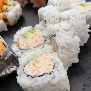 a plate of sushi rolls and a bowl of rice