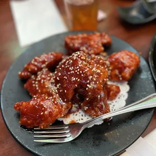 a plate of chicken wings with sesame seeds