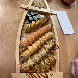 a wooden boat filled with sushi