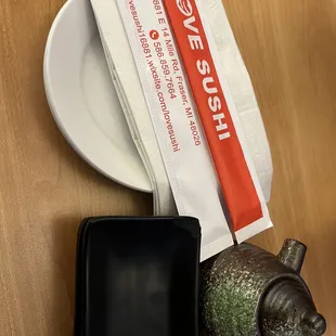 a teapot, a plate, and a tea bag on a table