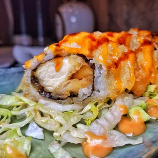 a plate of sushi with lettuce and sauce