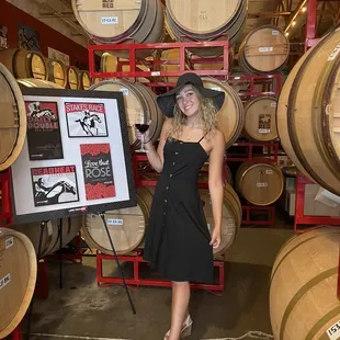 a woman standing in front of barrels