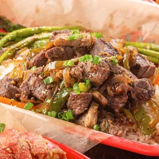 Savory steak bites dinner over a bed of white rice and asparagus